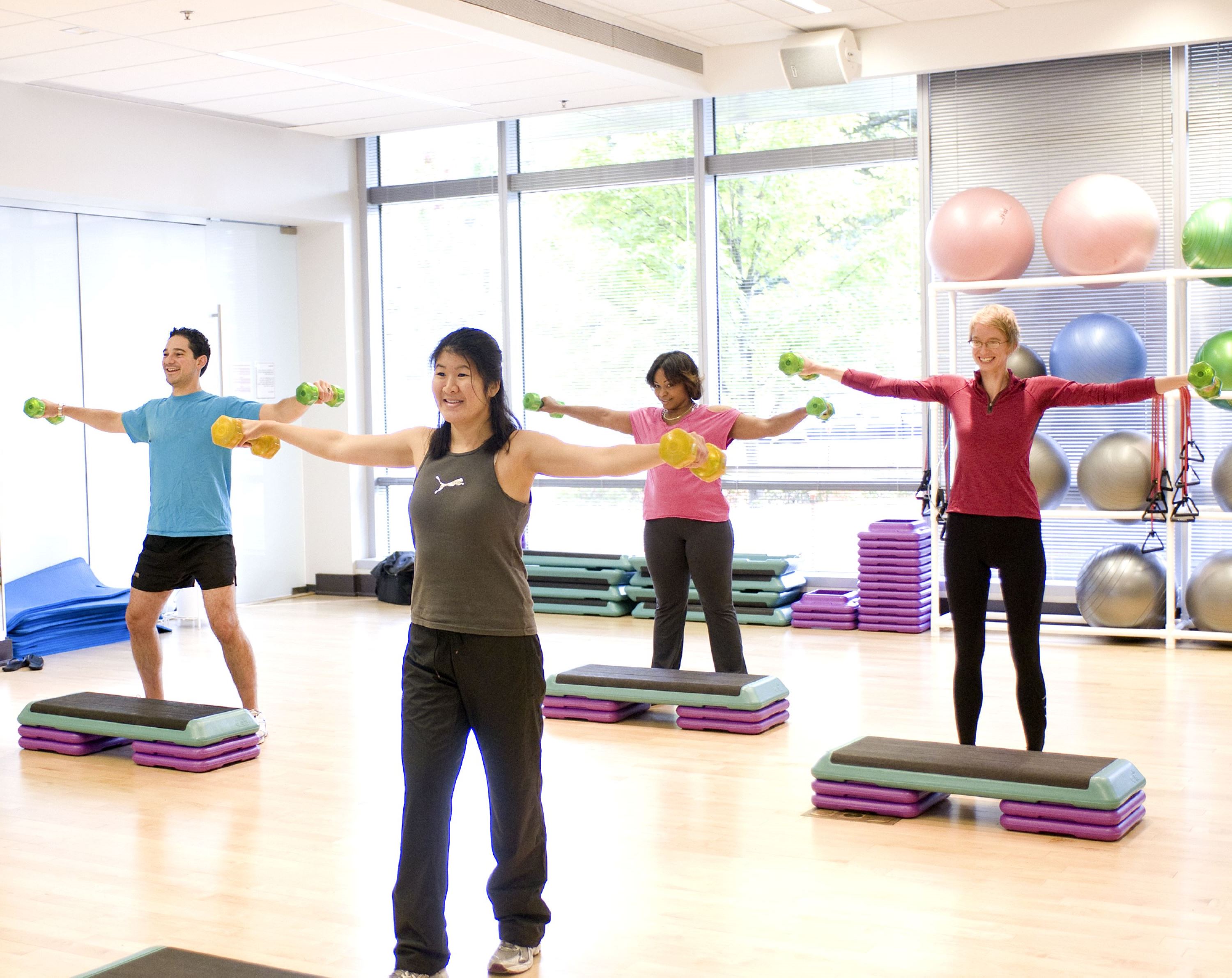 Dumbbells in both their outstretched hands building upper body strength while aerobicizing